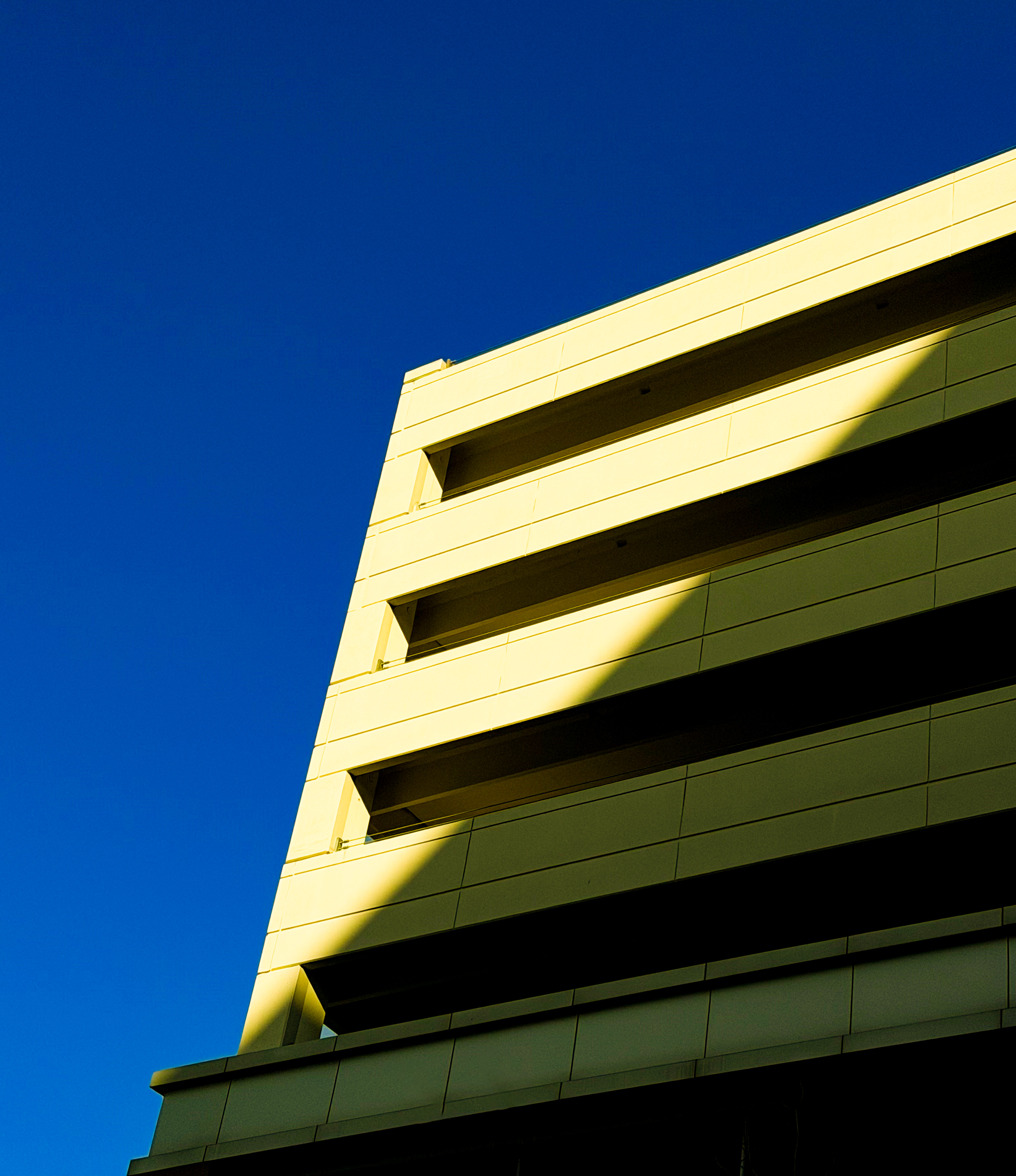 Building facade against deep blue sky